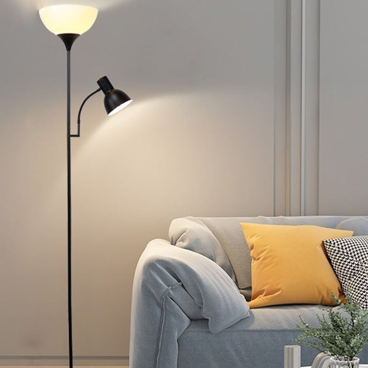 Schwarze Kombi-Stehlampe mit Leseleuchte neben grauem Sofa und Kissen