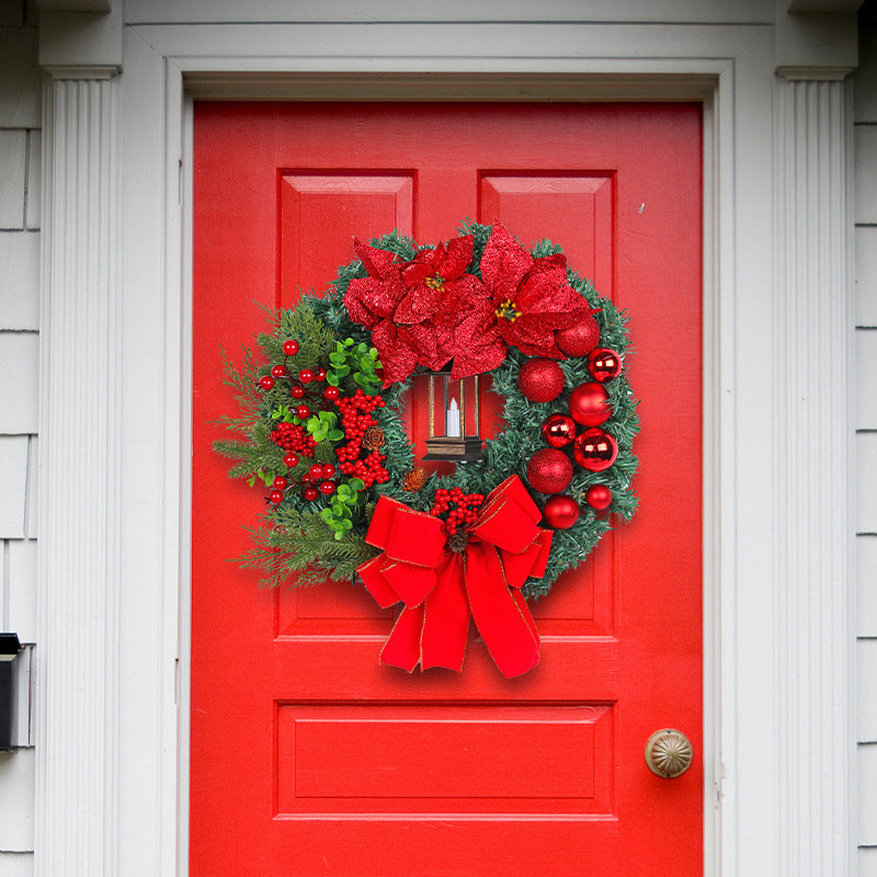 Weihnachtskranz mit dekorativer Laterne und roten Blumen