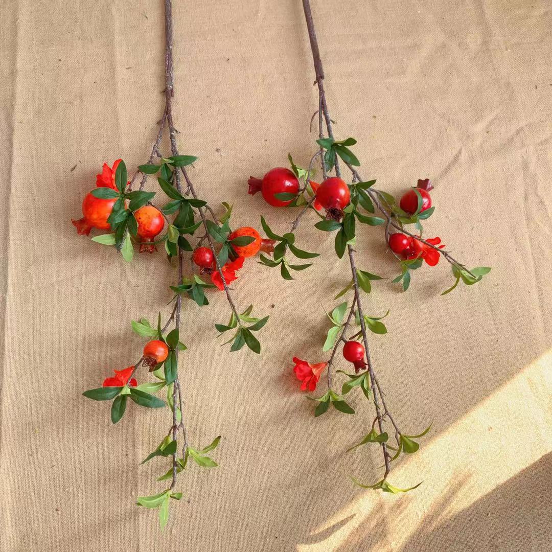 Dekorativer Granatapfel und Blumenzweig