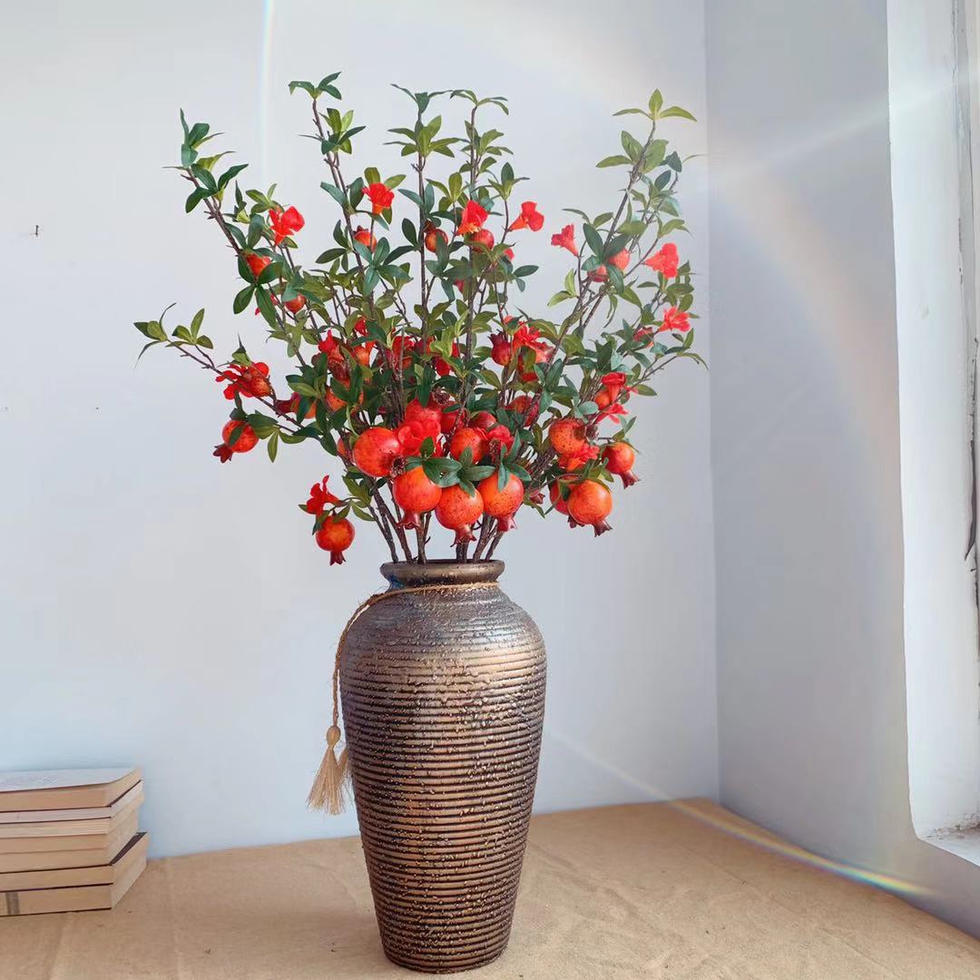 Dekorativer Granatapfel und Blumenzweig