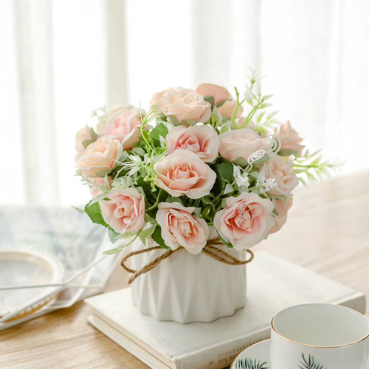 Seidenblumenarrangement in einem mit Schnur umwickelten Keramikpflanzer als Tischmittelpunkt