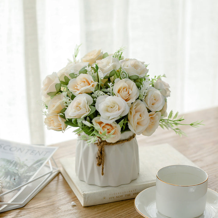 Seidenblumenarrangement in einem mit Schnur umwickelten Keramikpflanzer als Tischmittelpunkt