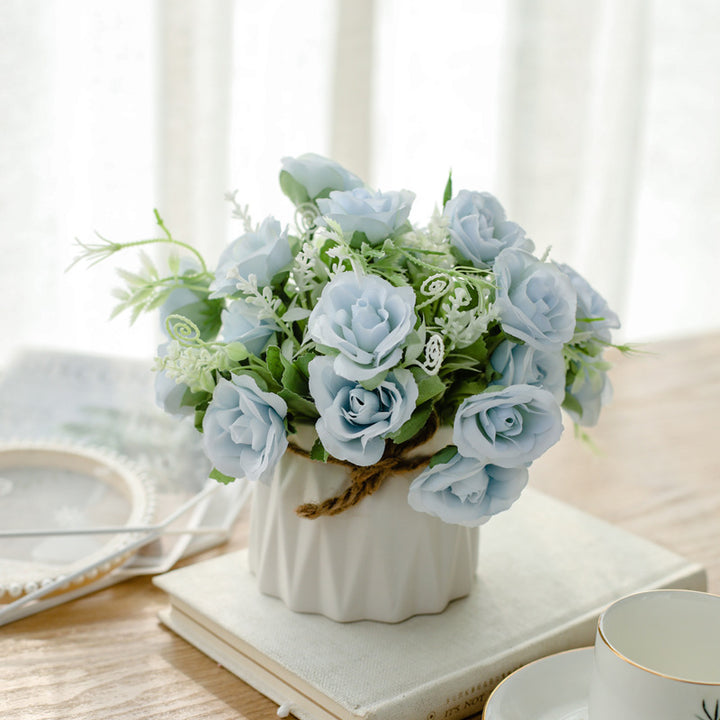 Seidenblumenarrangement in einem mit Schnur umwickelten Keramikpflanzer als Tischmittelpunkt