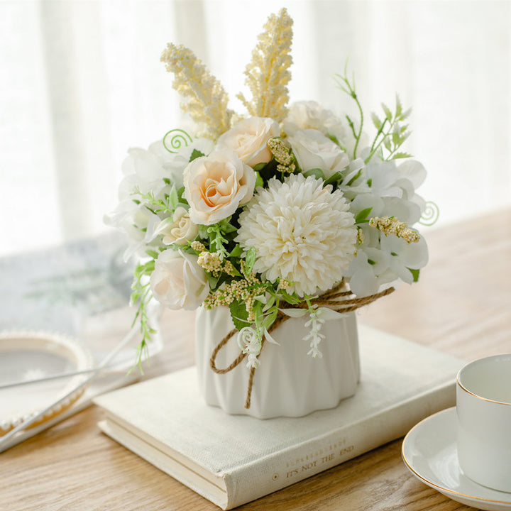 Seidenblumenarrangement in einem mit Schnur umwickelten Keramikpflanzer als Tischmittelpunkt