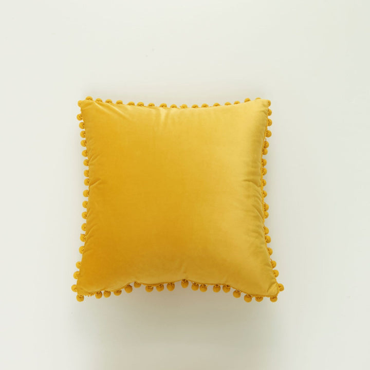 Dekoratives Samt-Kissen mit Pom-Pom-Bordüre