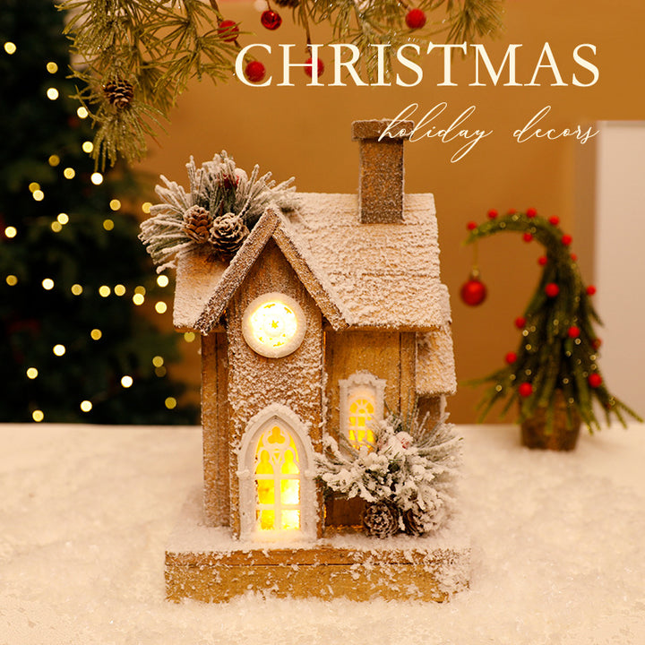 Beleuchtetes Weihnachts-Holzhaus mit Schneelandschaft