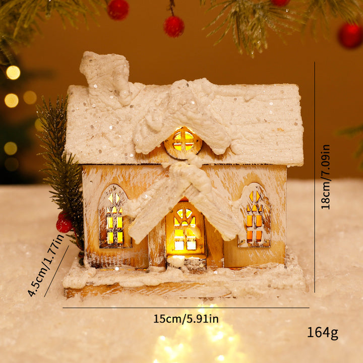 Beleuchtetes Weihnachts-Holzhaus mit Schneelandschaft