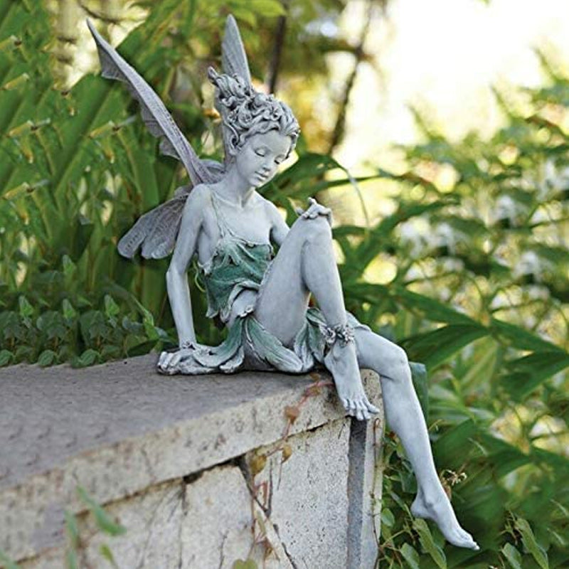 Statue einer sitzenden Fee im Garten