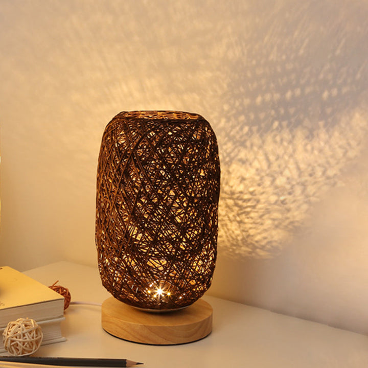 Dunkelbraune Tischlampe mit Flechtmuster auf Nachttisch, warm beleuchtet