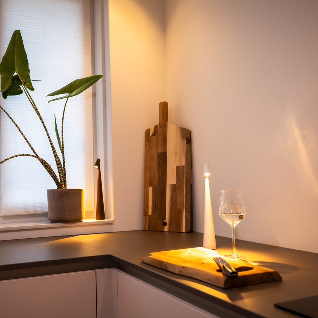 Zwei minimalistische Tischlampen auf Tisch mit Weinglas