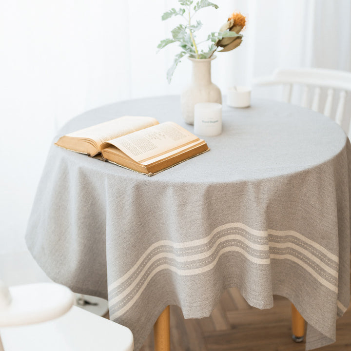 Rechteckige Tischdecke aus Baumwoll‑Leinen‑Mischung mit dezenter Streifenbordüre und dekorativen Quasten