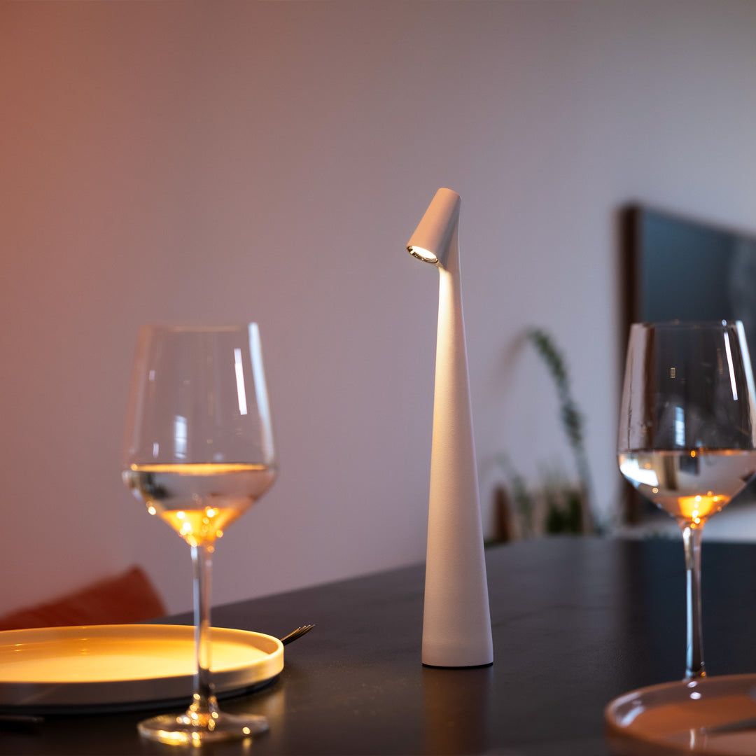 Schlichte Designlampe auf modernem Tisch mit Weingläsern
