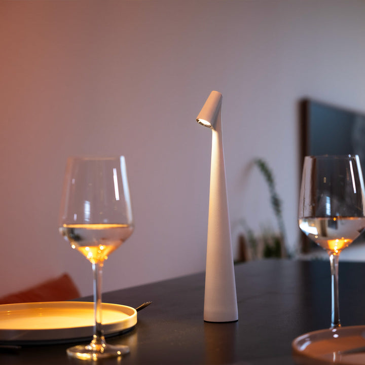 Schlichte Designlampe auf modernem Tisch mit Weingläsern