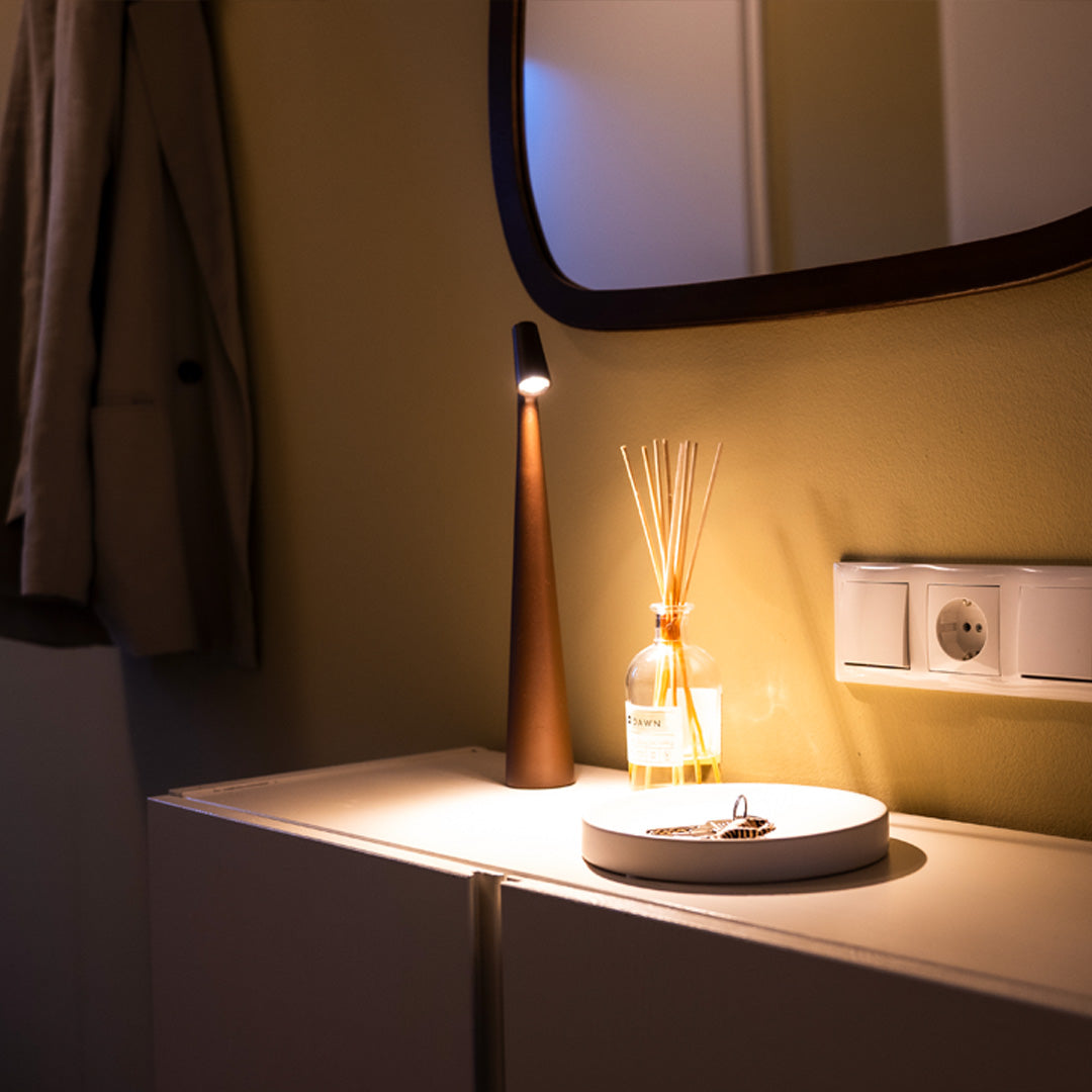 Schlanke Tischlampe auf Hotelzimmer-Nachttisch mit rundem Spiegel

