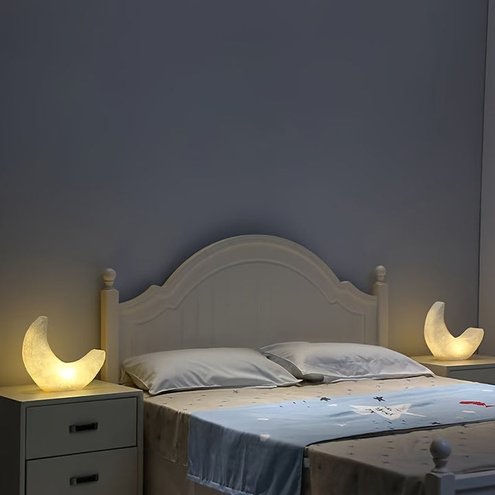Zwei mondförmige Nachtlichter auf Nachttischen links und rechts neben einem Bett