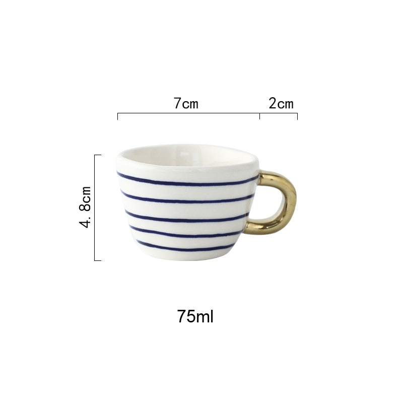 Tasse mit abstraktem geometrischen Muster und goldenem Henkel