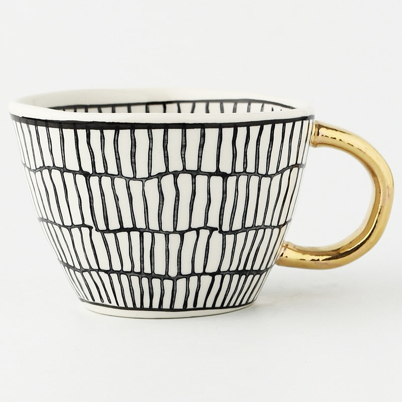 Tasse mit abstraktem geometrischen Muster und goldenem Henkel