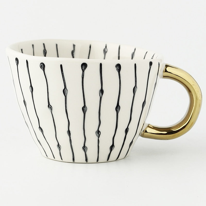 Tasse mit abstraktem geometrischen Muster und goldenem Henkel