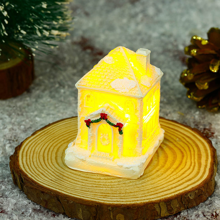 Beleuchtetes Weihnachtsdorfhaus mit festlicher Dekoration Karnz