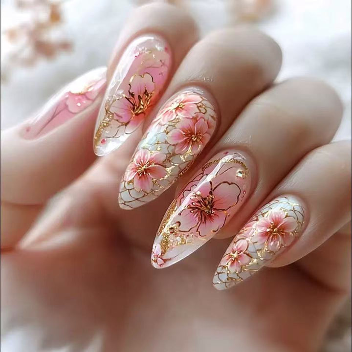 Kunstnägel mit floralen Akzenten und goldenen Details Karnz