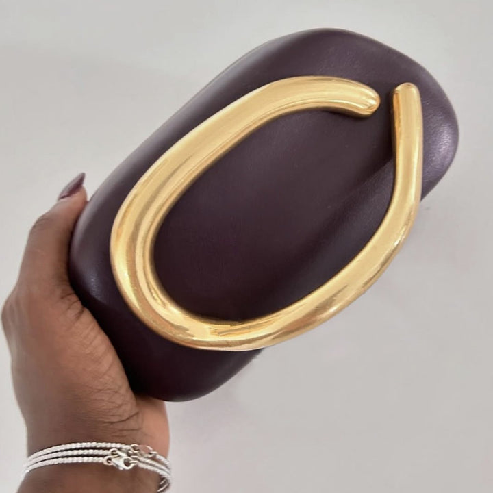 Statement Clutch mit skulpturalem Griff Karnz