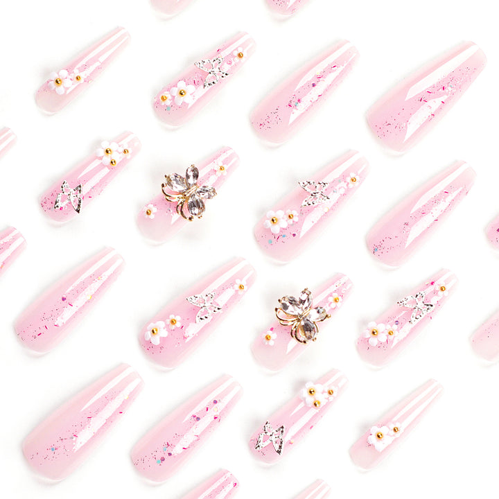 Kunstvolle Nagelverlängerungen mit Glitzer und floralen Akzenten Karnz