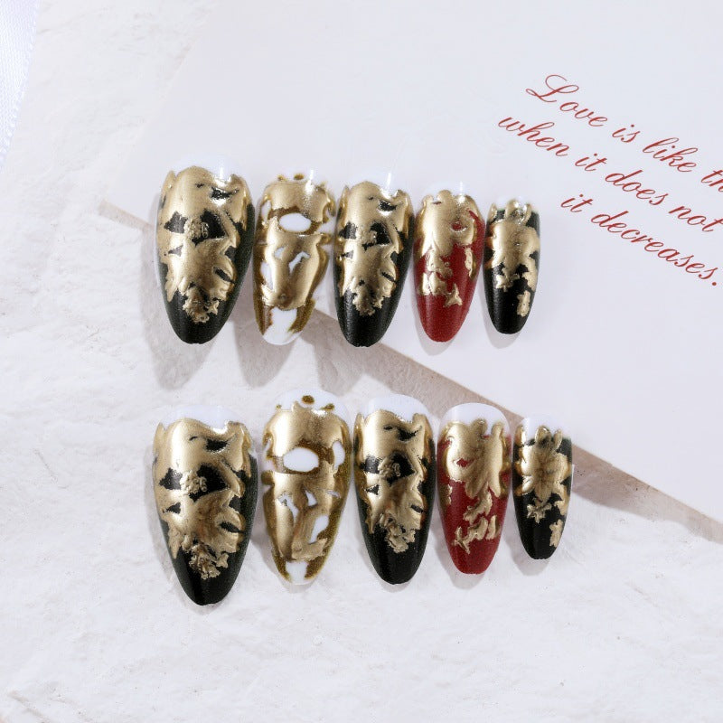 Elegante Kunstnägel mit Gold- und Schwarzmuster Karnz
