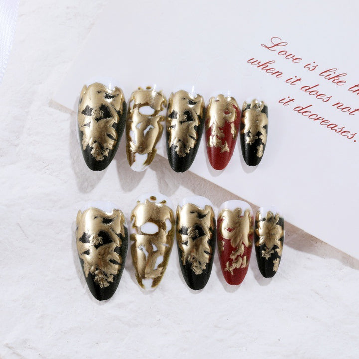 Elegante Kunstnägel mit Gold- und Schwarzmuster Karnz