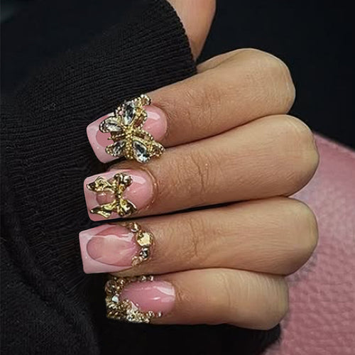 Glamouröses Kunstnagelset mit floralen Akzenten und Glitzerverzierungen Karnz