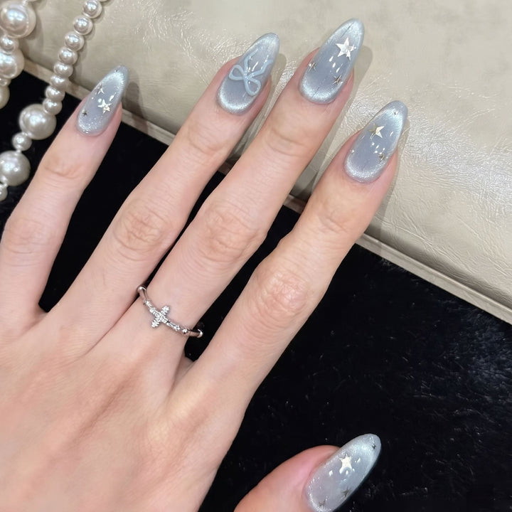 Dekorativer Stiletto Press-On Nagelset mit Stern- und Bogenakzenten Karnz