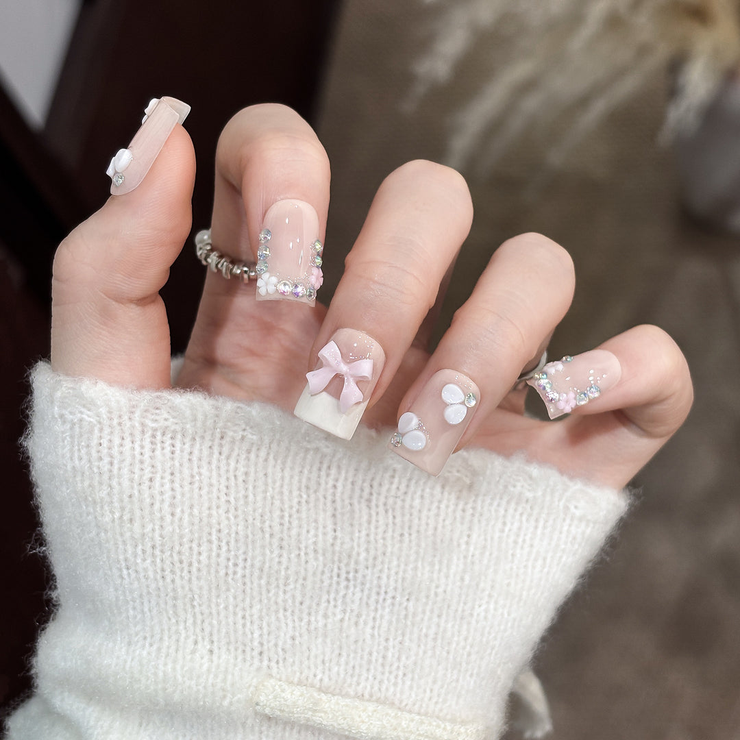 Dekoratives Nagelkunstset mit floralen Details und Schleifenakzenten