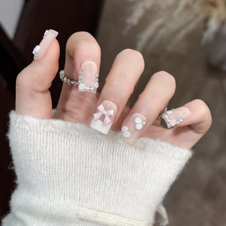 Dekoratives Nagelkunstset mit floralen Details und Schleifenakzenten