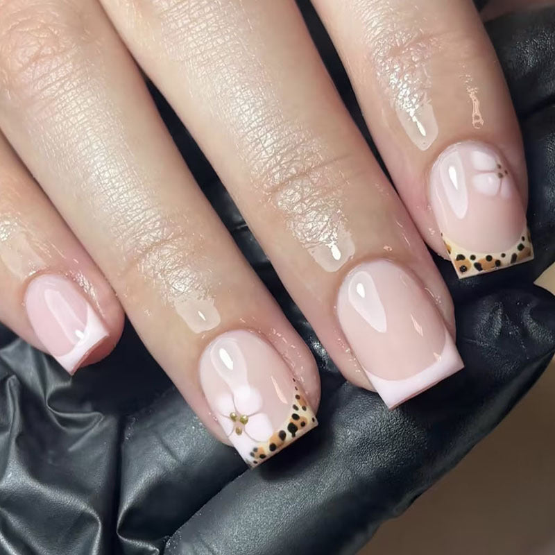 Kunstnagelset mit eleganter französischer Spitze und floralem Akzent Karnz
