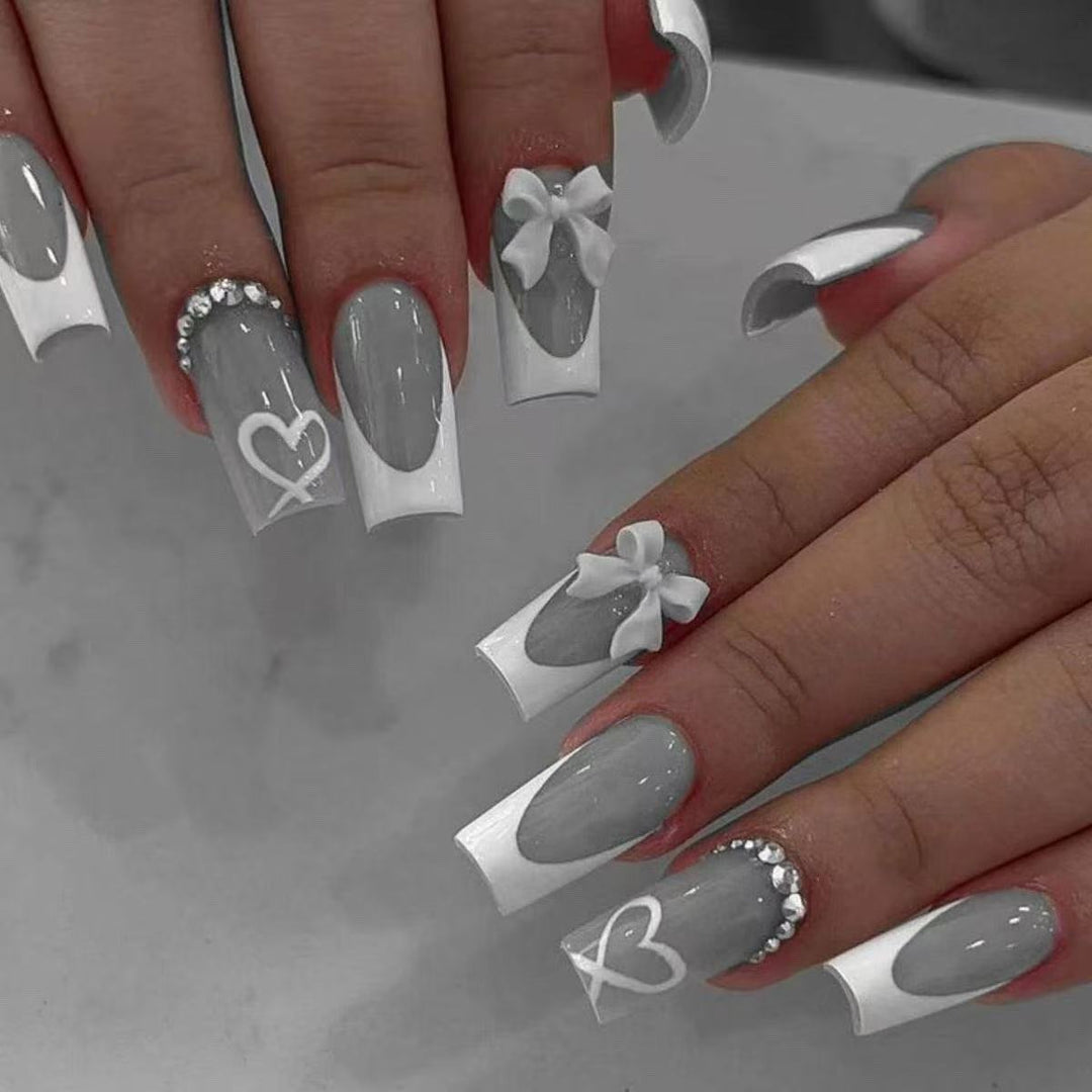 Kunstnagelset mit eleganten Schleifen- und Glitzerverzierungen Karnz