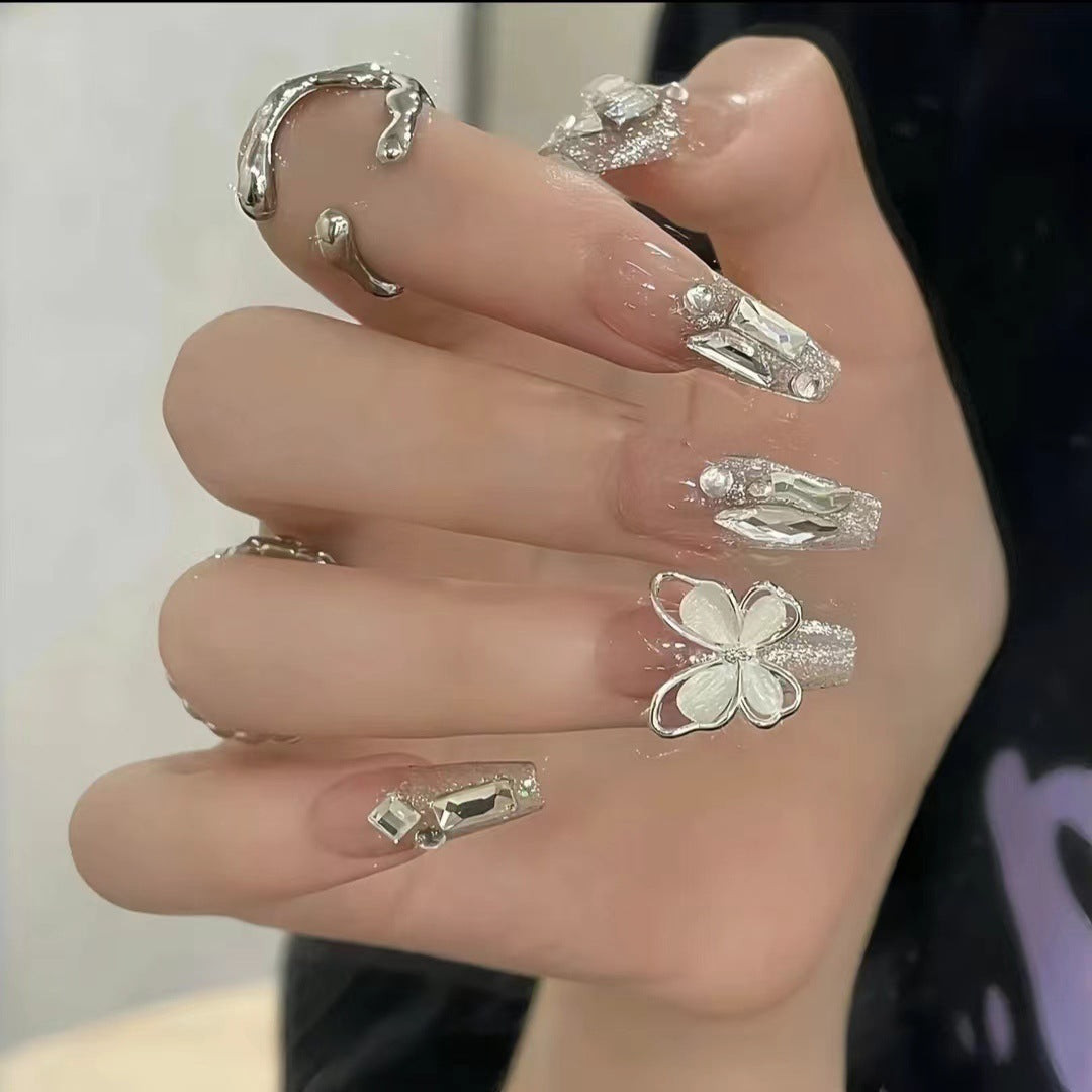 Kunstvolle Nagelkunst mit Schmetterlings- und Perlendetails Karnz