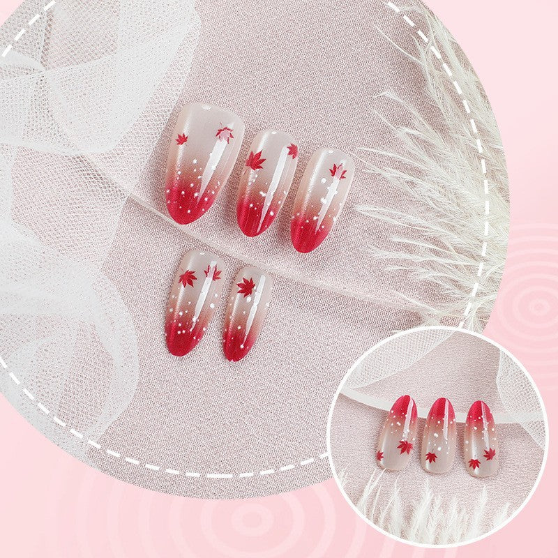 Kunstnagelset mit elegantem Rot-Ombré-Look und zarten Ahornblättern Karnz