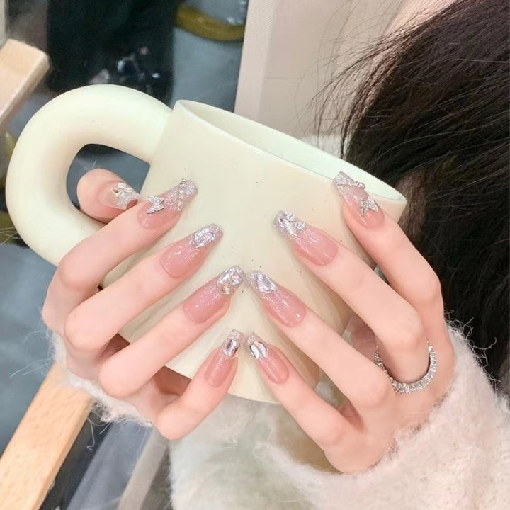 Kunstvolle Nagelkunst mit Schmetterlings- und Perlendetails Karnz