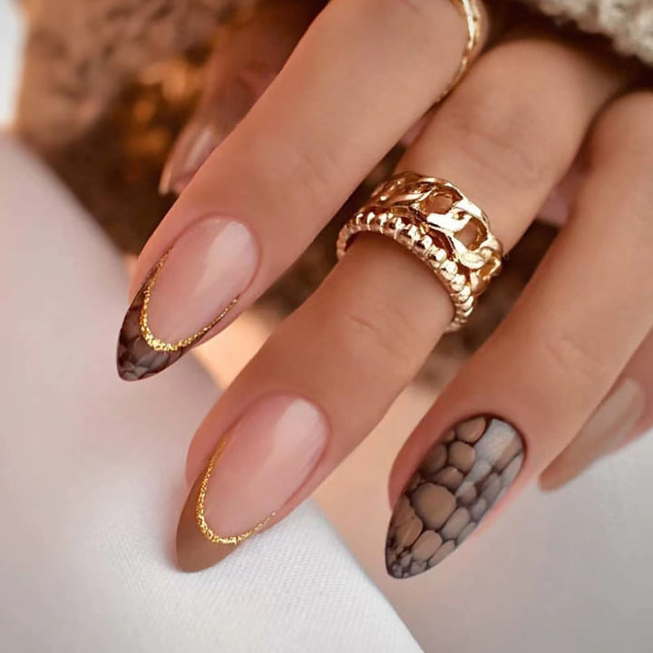 Kunstvolle Stiletto-Nägel mit elegantem Goldverzierung Karnz