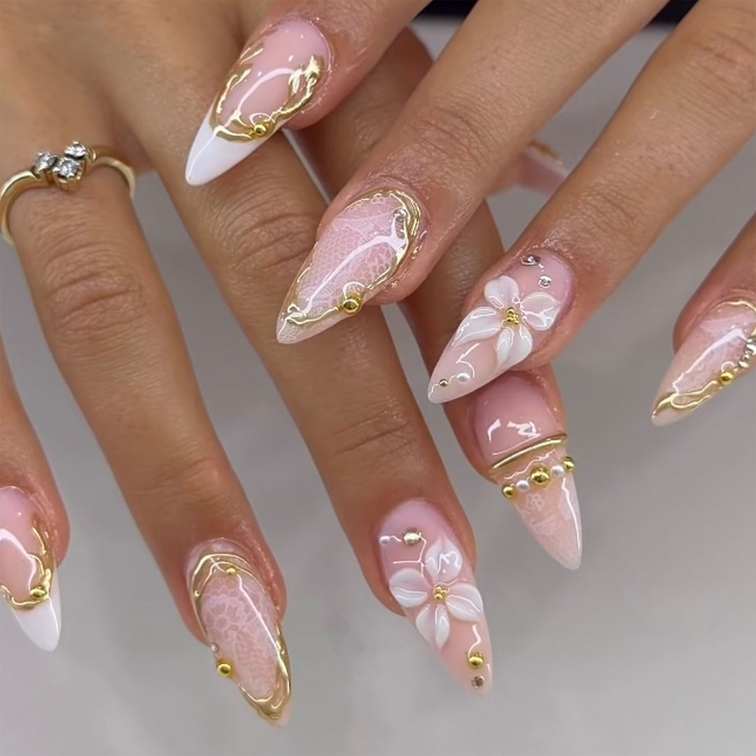 Kunstvolle Nagelverlängerungen mit filigranen Blüten- und Goldverzierungen Karnz