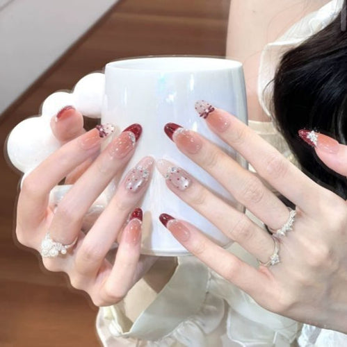 Künstlerisches Langes Stiletto Press-On Nagelset mit Schleife und Edelsteinakzenten Karnz