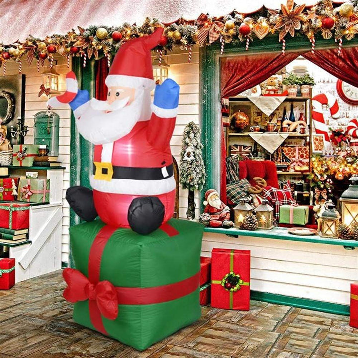 Aufblasbare Weihnachtsmann-Dekorationsfigur auf Geschenkpaket