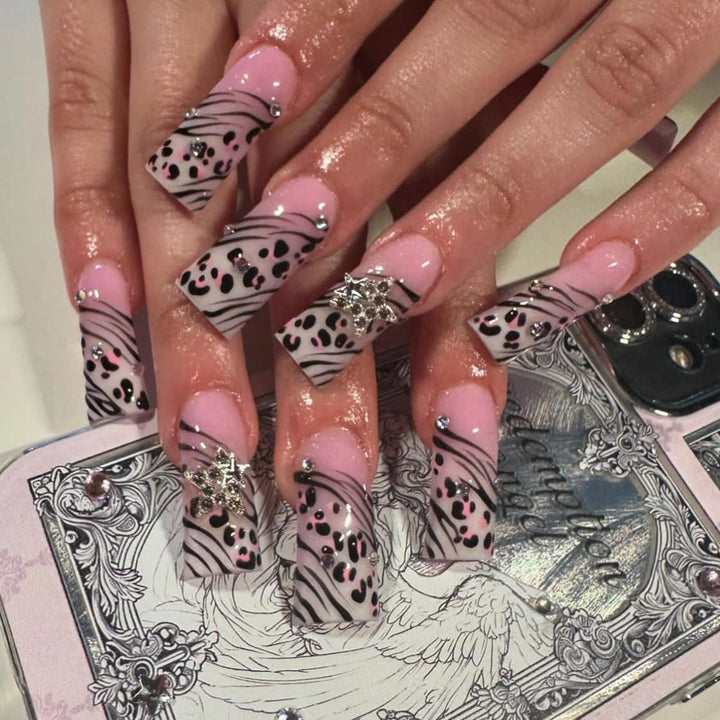 Kunstvolle Nagelkunst mit Zebramuster und Glitzerakzenten Karnz