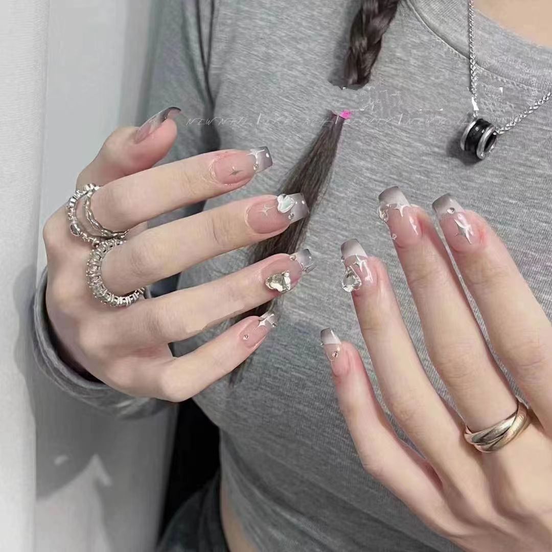 Kunstvolle Nagelkunst mit Schmetterlings- und Perlendetails Karnz