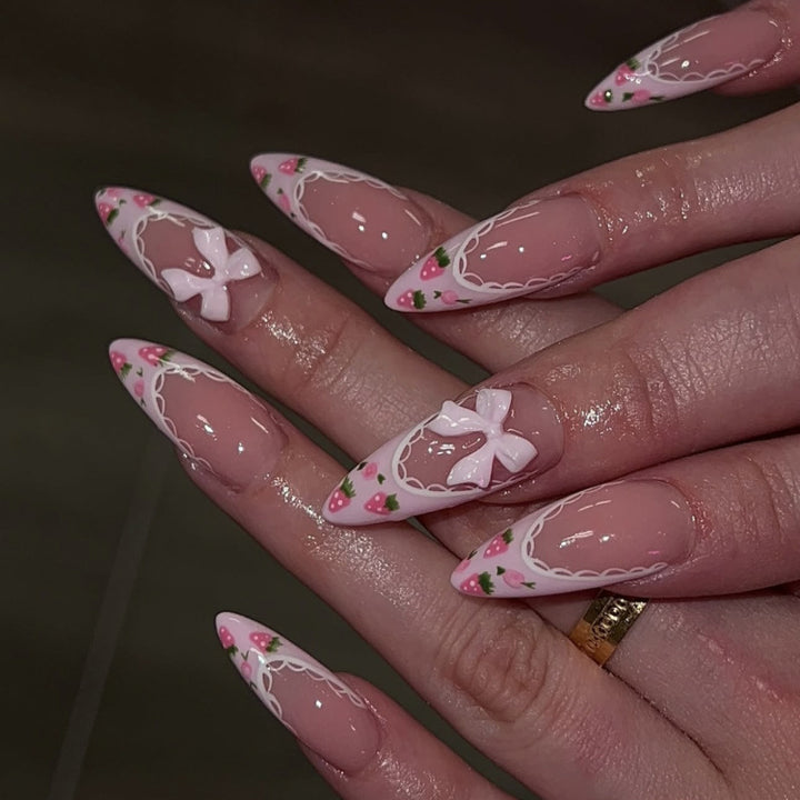 Kunstvolle Stiletto-Nägel mit floralen Akzenten und Schleifenverzierungen Karnz