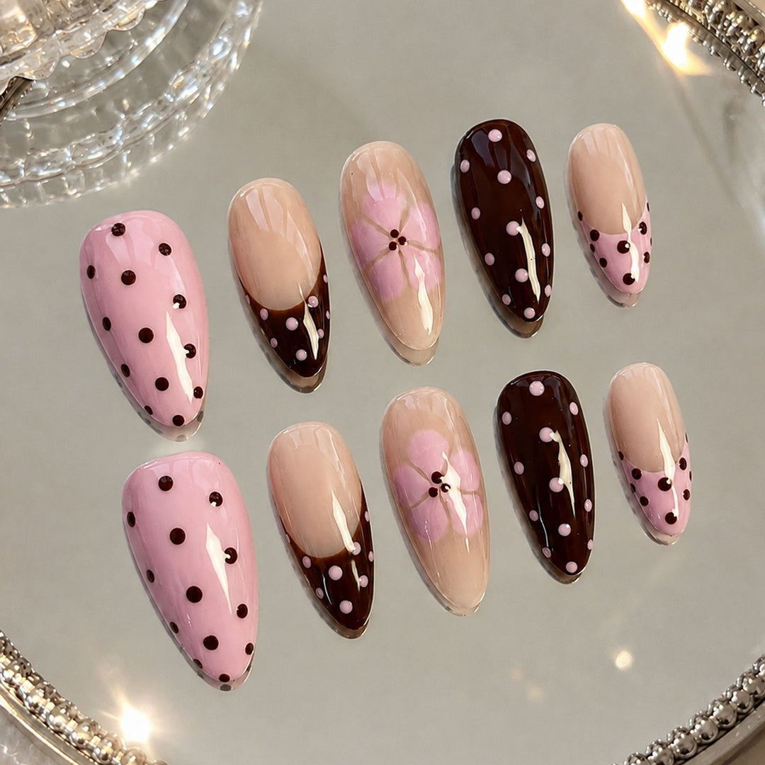 Kunstnagelset mit verspielten Punkten und floralen Akzenten Karnz