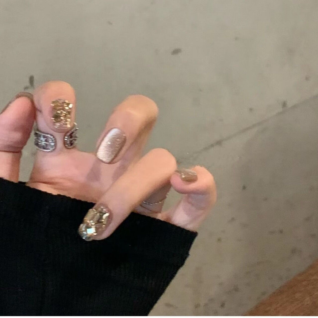 Kunstnagelset mit elegantem Glitzermuster und goldenen Akzenten Karnz
