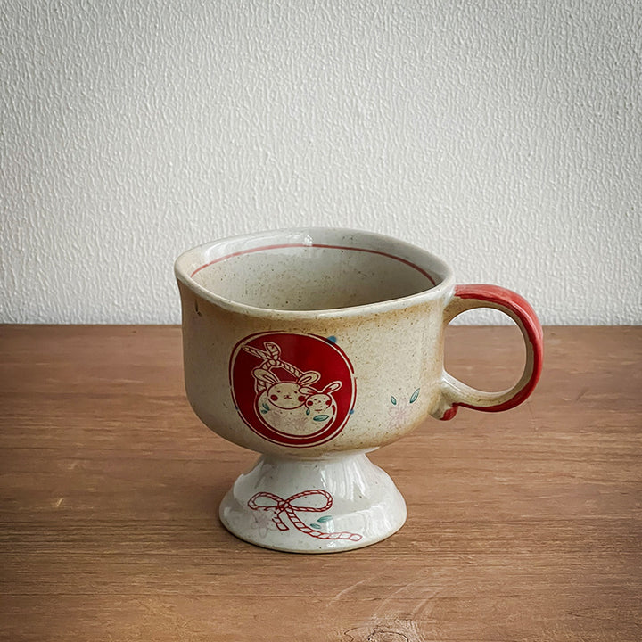 Keramik-Fußbecher mit Henkel und handbemalter Hasen-Illustration