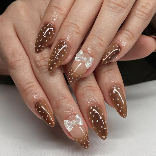 Kunstvolle Stiletto-Nägel mit zartem Schleifenmotiv Karnz