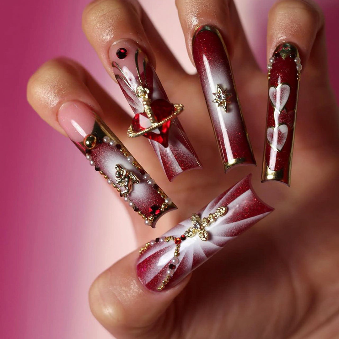 Kunstvolle Nagelkunst mit Glitzer- und Herzmotiven Karnz