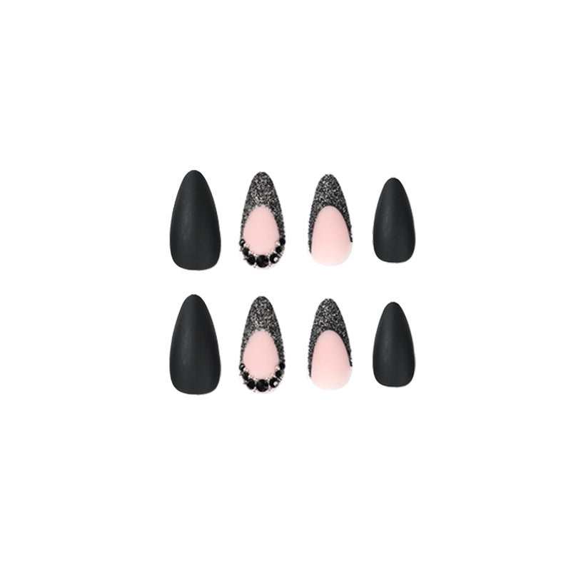 Kunstvolle Stiletto-Nägel mit elegantem Schwarz-Design und Glitzerakzenten Karnz